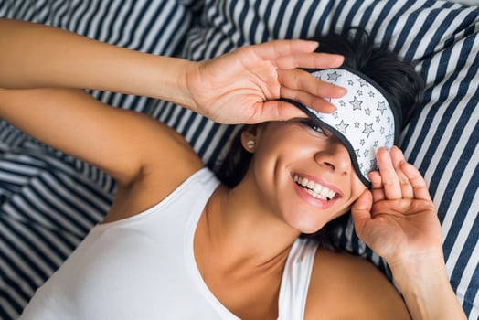 pretty sexy woman lying in bed in morning, wake up early, sleeping in mask photo