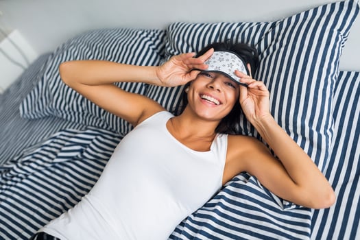 pretty sexy woman lying in bed in morning, wake up early, sleeping in mask photo
