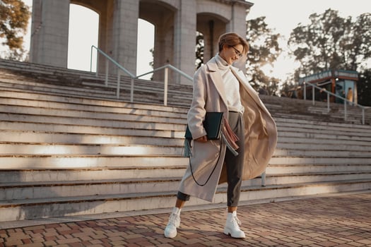 stylish fashionable woman walking in street in elegant style coat photo