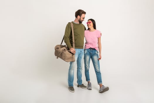 couple smiling woman and man in sweatshirt with travel bag photo
