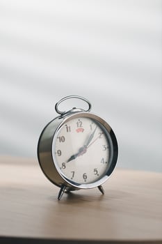 old mechanical alarm clock on wooden table in a living room. photo