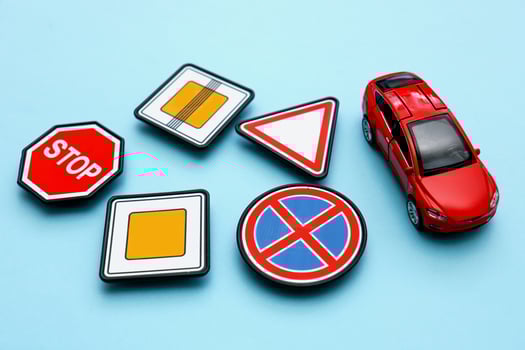 toy road signs and a red car on a blue background photo