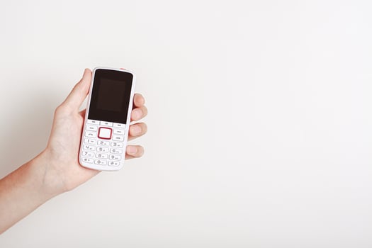 Hand holding an old-fashioned white push-button telephone photo