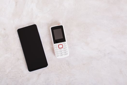 Alternative between modern smartphone and old-fashioned push-button phone top view photo