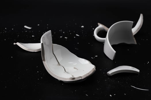 Large white mug with cracks. White cup for tea or soup with cracks isolated on dark background. Broken ceramic cup close up. symbol of divorce or loss photo