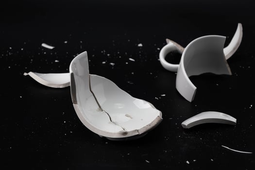 Large white mug with cracks. White cup for tea or soup with cracks isolated on dark background. Broken ceramic cup close up. symbol of divorce or loss photo