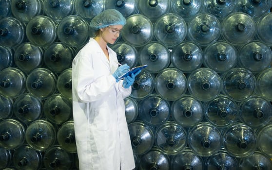 Female researcher carrying out scientific research in drinking water factory photo