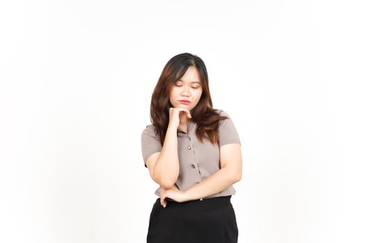 sad looking Asian woman is seen looking down and deep in thought with a white background photo