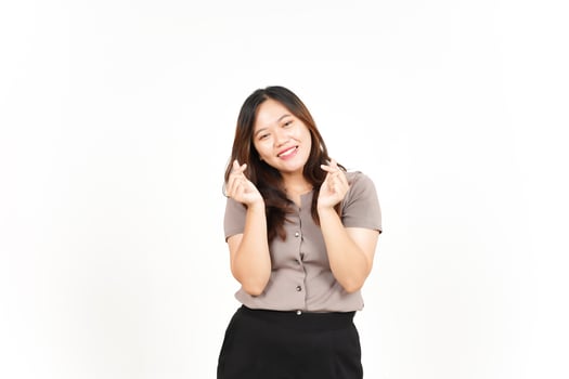 An Asian woman is showing the Korean love sign with a white background, smiling brightly photo