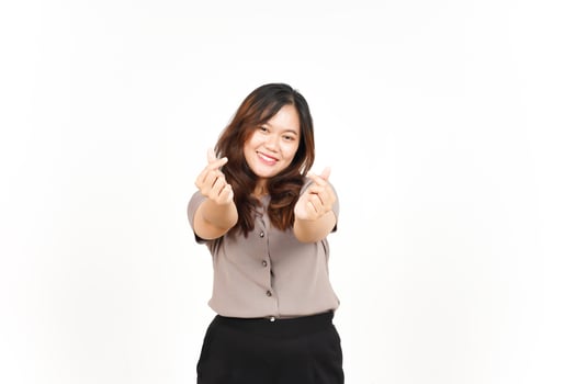 An Asian woman is showing the Korean love sign with a white background, smiling brightly photo