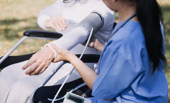 Asian young woman nurse at nursing home take care disabled senior man. Caregiver doctor serve physical therapy for older elderly patient to exercise and practice walking on walker or cane at backyard. photo