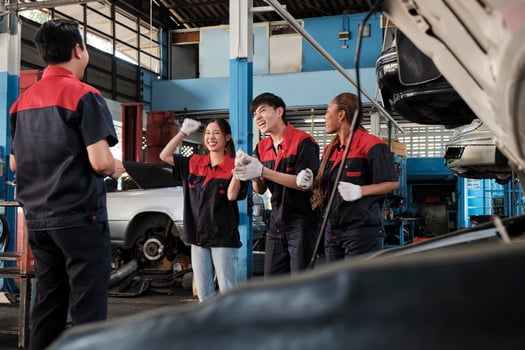 Male professional supervisor engineer and mechanic workers are cheerful with finished repair work, teamwork achievements at car service garage, and harmonious maintenance jobs in automotive industry. photo