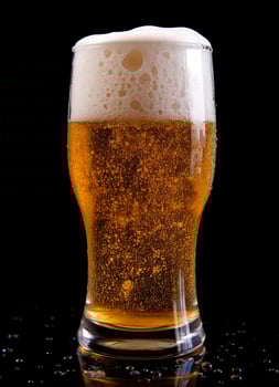 A glass of cold fresh beer with cap of foam. Splash of foam with tasty american beer. Beer day concept by AI Generated photo