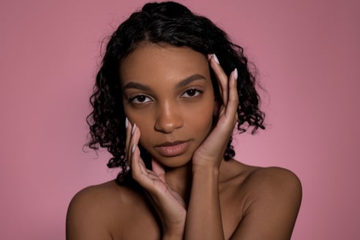 Closeup studio beauty portrait of african american girl on pink background. Skincare and cosmetology concept photo
