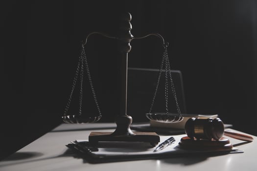 Business and lawyers discussing contract papers with brass scale on desk in office. Law, legal services, advice, justice and law concept picture with film grain effect photo