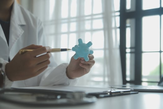 Doctor and patient sitting and talking at medical examination at hospital office, close-up. Therapist filling up medication history records. Medicine and healthcare concept. photo