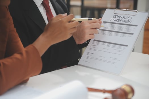 Business and lawyers discussing contract papers with brass scale on desk in office. Law, legal services, advice, justice and law concept picture with film grain effect photo