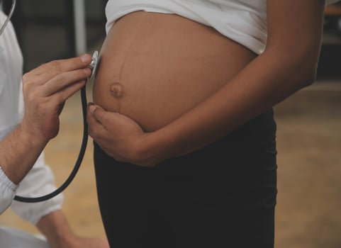 Female doctor is checking pregnant woman with stethoscope. Concept caring for pregnant woman photo