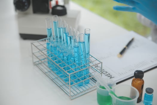 Scientist or medical in lab coat working in biotechnological laboratory, Microscope equipment for research with mixing reagents in glass flask in clinical laboratory. photo