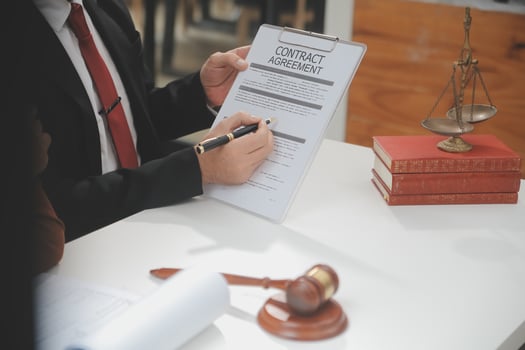 Business and lawyers discussing contract papers with brass scale on desk in office. Law, legal services, advice, justice and law concept picture with film grain effect photo