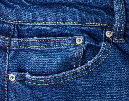 Blue jeans front pocket with buttons, close up photo