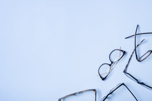 Eyeglasses on blue background with copy space. Optical store, vision test, stylish glasses concept photo