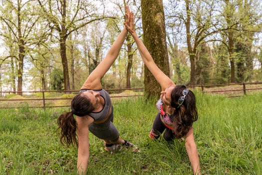beautiful sporty middle-aged women having fun doing push-ups in the middle of the grass photo