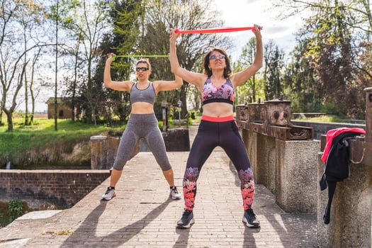 beautiful middle aged women doing exercises outdoors with a resistance band photo