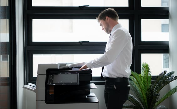 Businessman in office working with copier. photo
