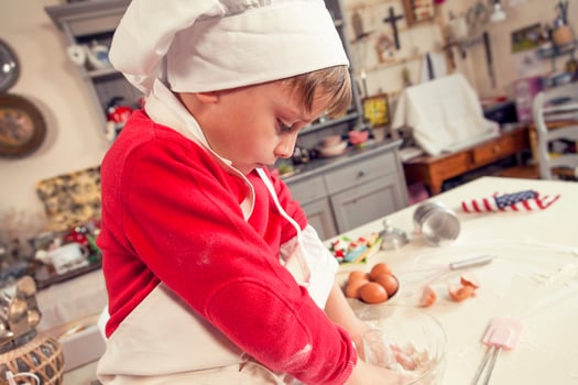 cute child in the kitchen while mixing the dough photo