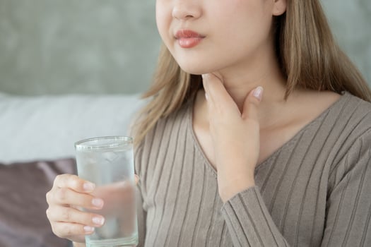 Asian woman put her hand on her neck due to a sore throat. female tonsillitis causes a inflammation. treated by taking water, taking antibiotics, consult a doctor, virus, corona virus, Influenza, flu photo