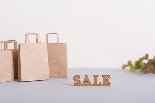 Green Friday sale lettering, paper bags and leaves on table photo