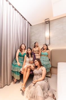 a group of Asian women in glamorous and luxurious clothes are sitting on the sofa with their friends after partying photo