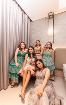 a group of Asian women in luxurious dresses are waiting for dinner in a hotel ballroom photo