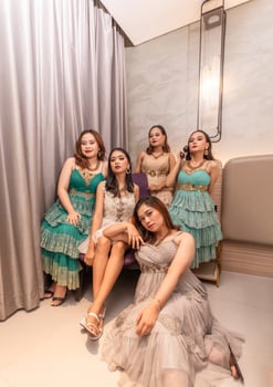a group of Asian women in glamorous and luxurious clothes are sitting on the sofa with their friends after partying photo