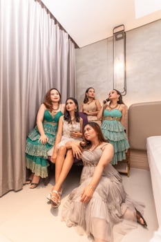 a group of Asian women in glamorous and luxurious clothes are sitting on the sofa with their friends after partying photo