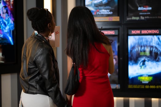 Both of young woman stand and watch the movie program to watch today. photo