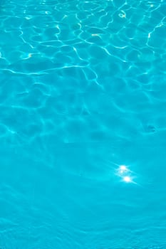 Azure transparent texture of water in a blue pool with splashes from the sun photo