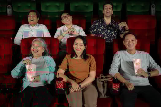 Group of asian senior friends watching comedy movie and laugh at the cinema with popcorn photo