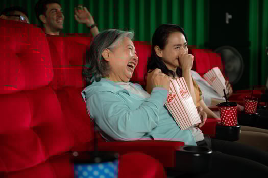 Group of asian senior friends watching comedy movie and laugh at the cinema with popcorn photo