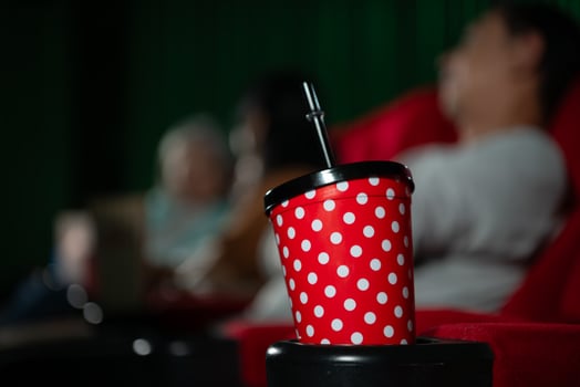 Cinema concept. People watching movie at cinema drink water and eating popcorn photo
