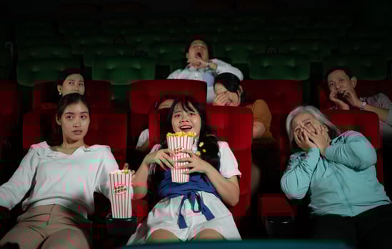 When watching scary ghost movies in theaters, moviegoers appear terrified. photo