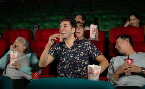 Group of asian senior friends watching comedy movie and laugh at the cinema with popcorn photo