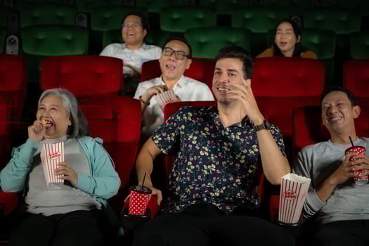 Group of asian senior friends watching comedy movie and laugh at the cinema with popcorn photo