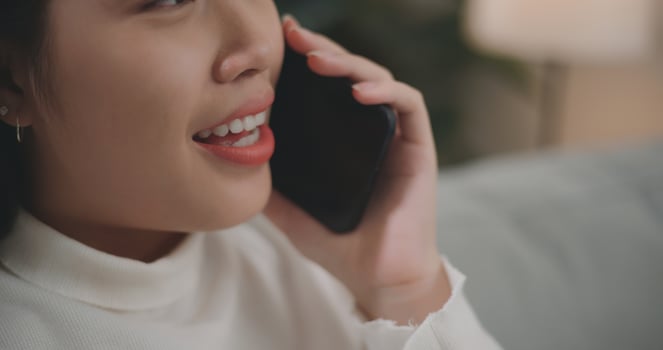 Asian woman talking with friends or family on a smartphone photo