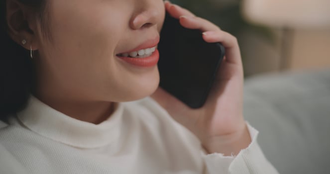 Asian woman talking with friends or family on a smartphone photo