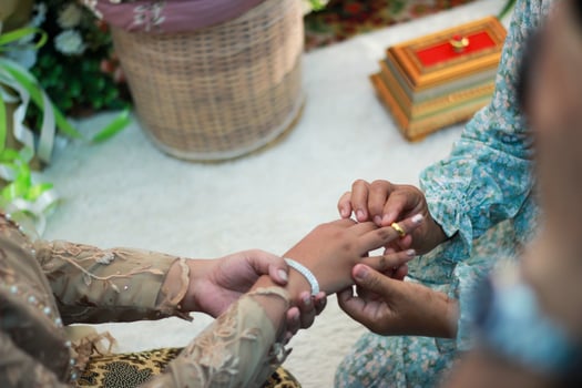 cut of a woman's hand to which her boyfriend's mother puts on an engagement ring. photo