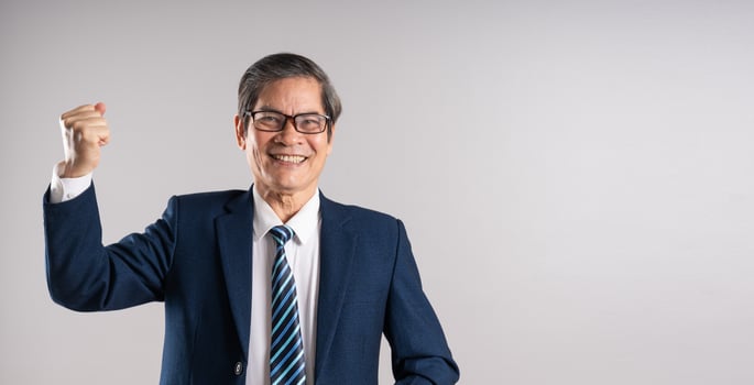 Portrait of an elderly Asian businessman, posing on a blue background photo