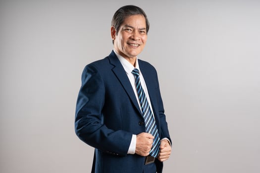 Portrait of an elderly Asian businessman, posing on a blue background photo