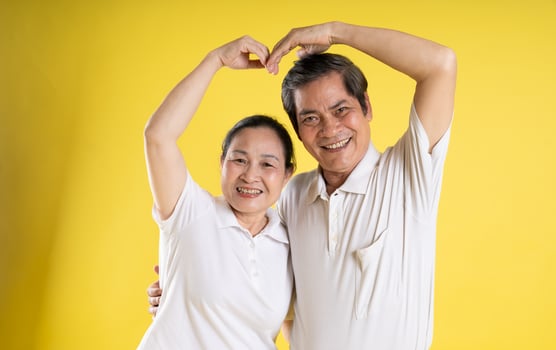 portrait of middle aged asian couple posing on yellow background photo